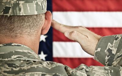 Military soldier saluting American flag