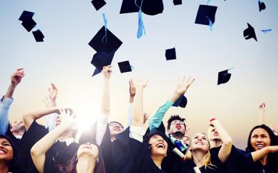 Graduates throwing mortar boards in the air