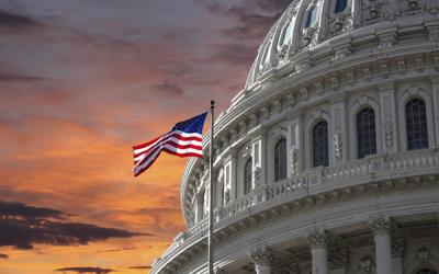 Capitol Dome and U.S. Flag against dramatic sky